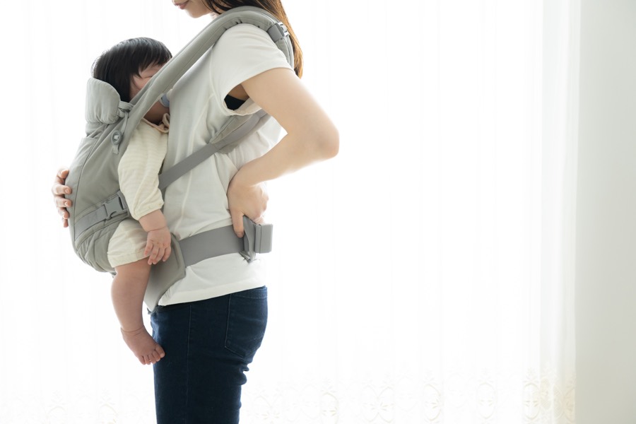 抱っこ姿勢で反り腰になっている産後のお母さん